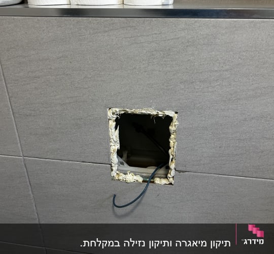 קיר עם חור פתוח וחוט חשמל